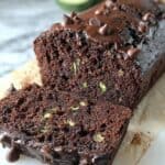 Rich chocolate zucchini bread with chocolate chips and glazed topping, perfect for baking lovers.