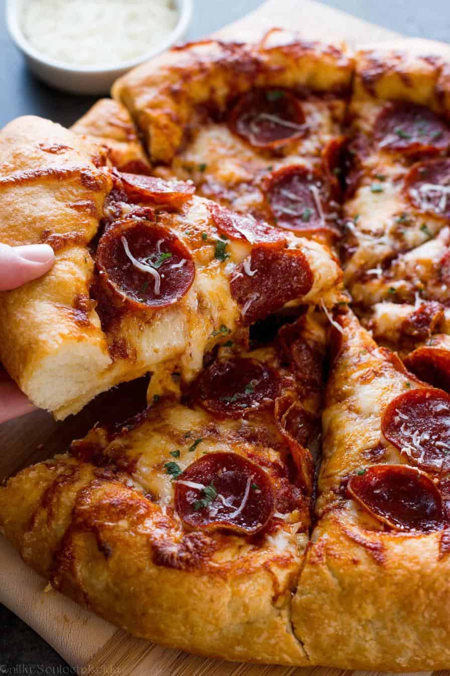 Savory pepperoni pizza with melted cheese, crispy crust, and fresh herbs on a wooden serving board. Perfect comfort food for any pizza lover.