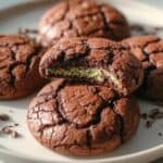 Rich chocolate cookies with gooey center and cracked surface on white plate, close-up of freshly baked cookies, gourmet chocolate treats, perfect for dessert or gift, bakery quality baked goods, thebakerswhisk.com.