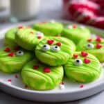 Colorful frog-shaped sugar cookies decorated with candy eyes and red heart sprinkles on a white plate. Perfect for Valentine's Day or fun themed parties.