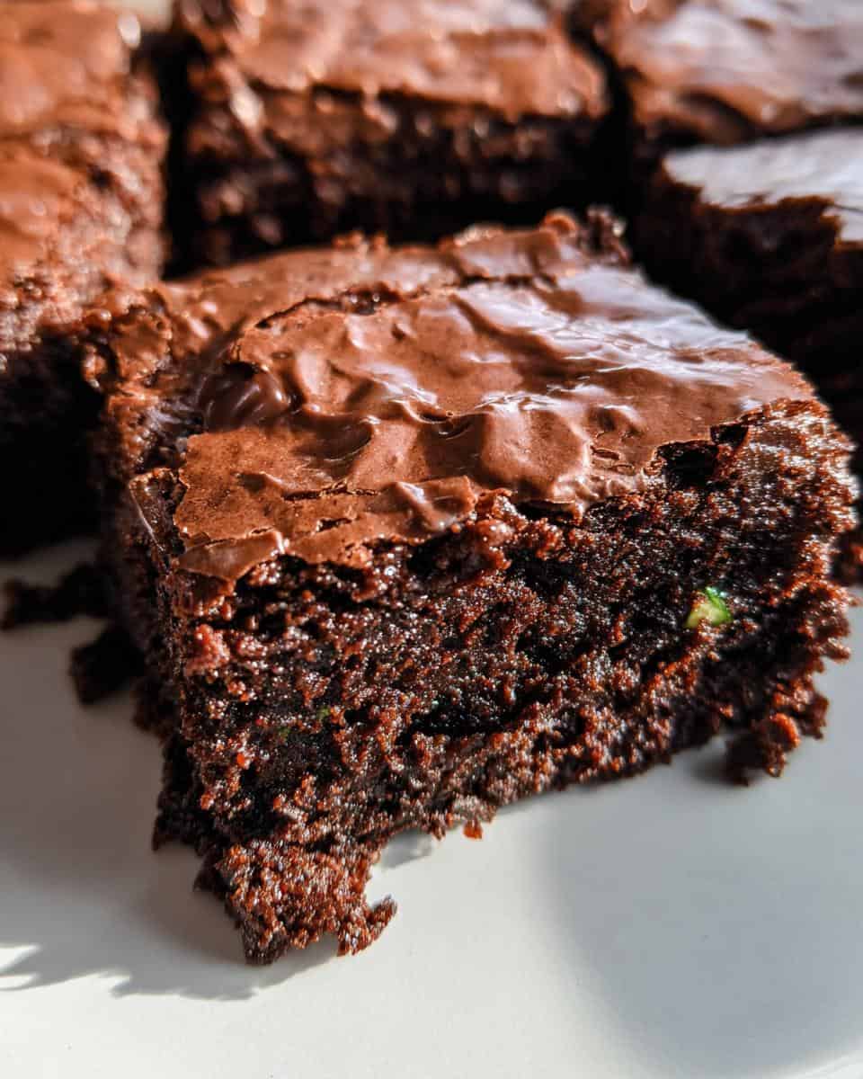 Rich, fudgy chocolate brownie with a gooey center and glossy chocolate topping, perfect for chocolate lovers and baked fresh.