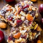 Chewy cherry almond granola bars with nuts and dried fruit on rustic wooden background. Healthy homemade snack, protein bars with almonds, dried cherries, and chocolate chips. Perfect for breakfast or energy boost.