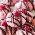 Freshly baked pink cherry cookies drizzled with chocolate and topped with cherry jam, perfect for dessert or special occasions. Delicious, colorful, and sweet baked treats from The Baker's Whisk.