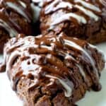 Rich chocolate chip cookie dough truffles drizzled with melted chocolate and white chocolate on a white plate, perfect for homemade dessert treats.