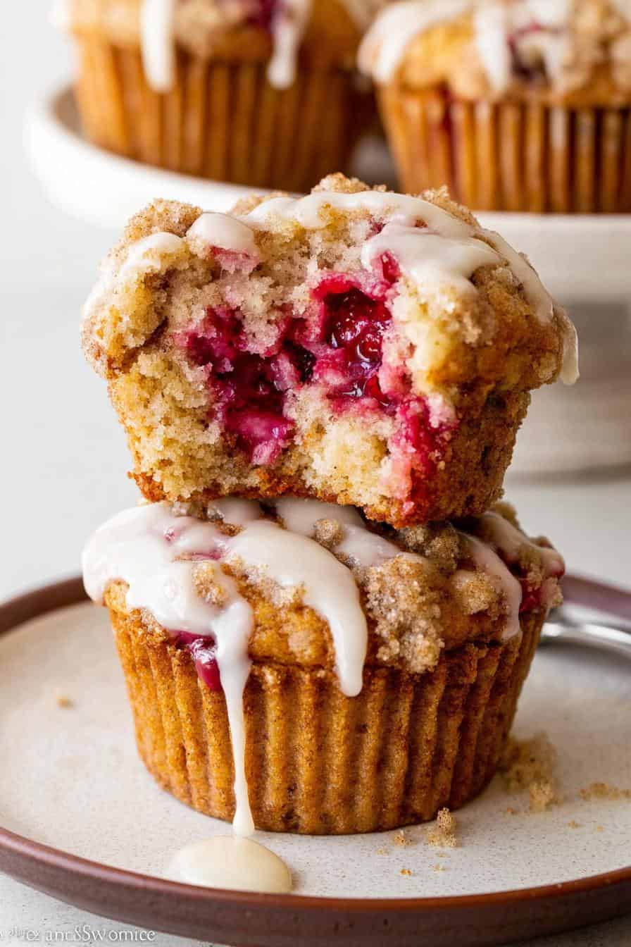 Moist cherry crumb muffin with streusel topping and icing drizzle on rustic plate, fresh baked cherry muffins from The Bakers Whisk bakery, perfect for breakfast or snack, delicious cherry dessert.