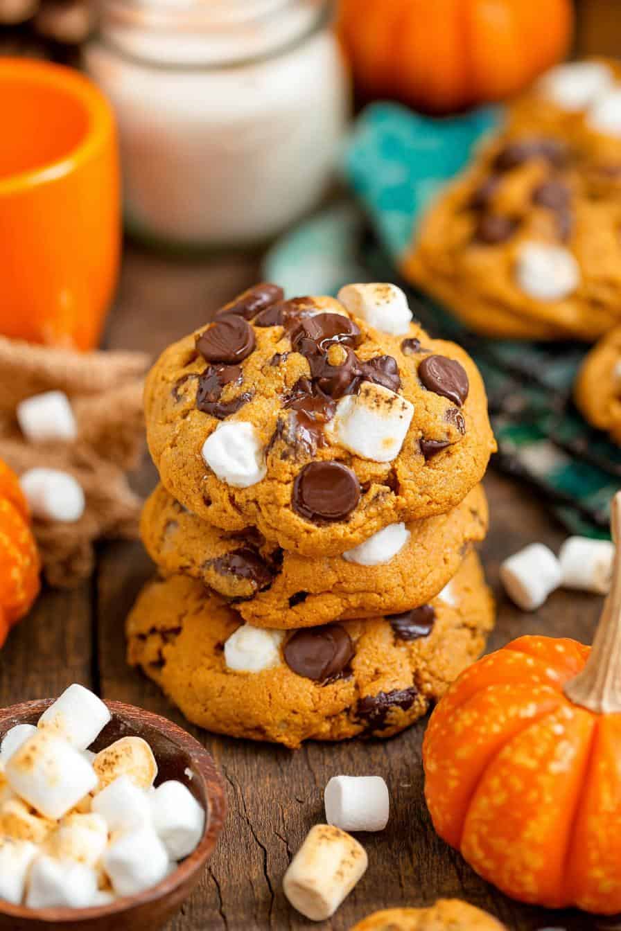 Delicious pumpkin chocolate chip cookies with marshmallows on rustic wooden table for fall baking and holiday treats.